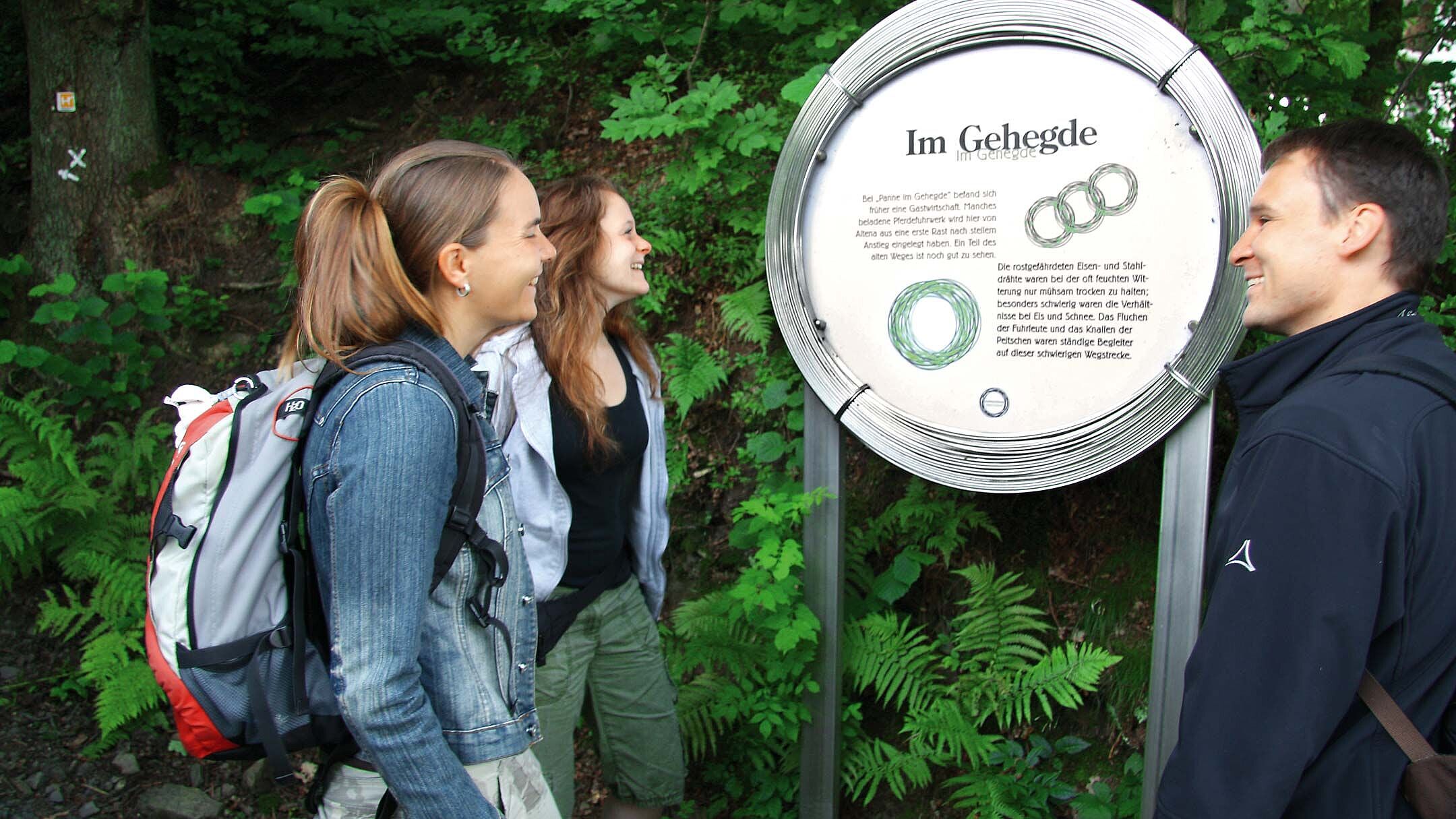 Gruppe von Wanderern vor einem Schild auf dem Drahthandelsweg