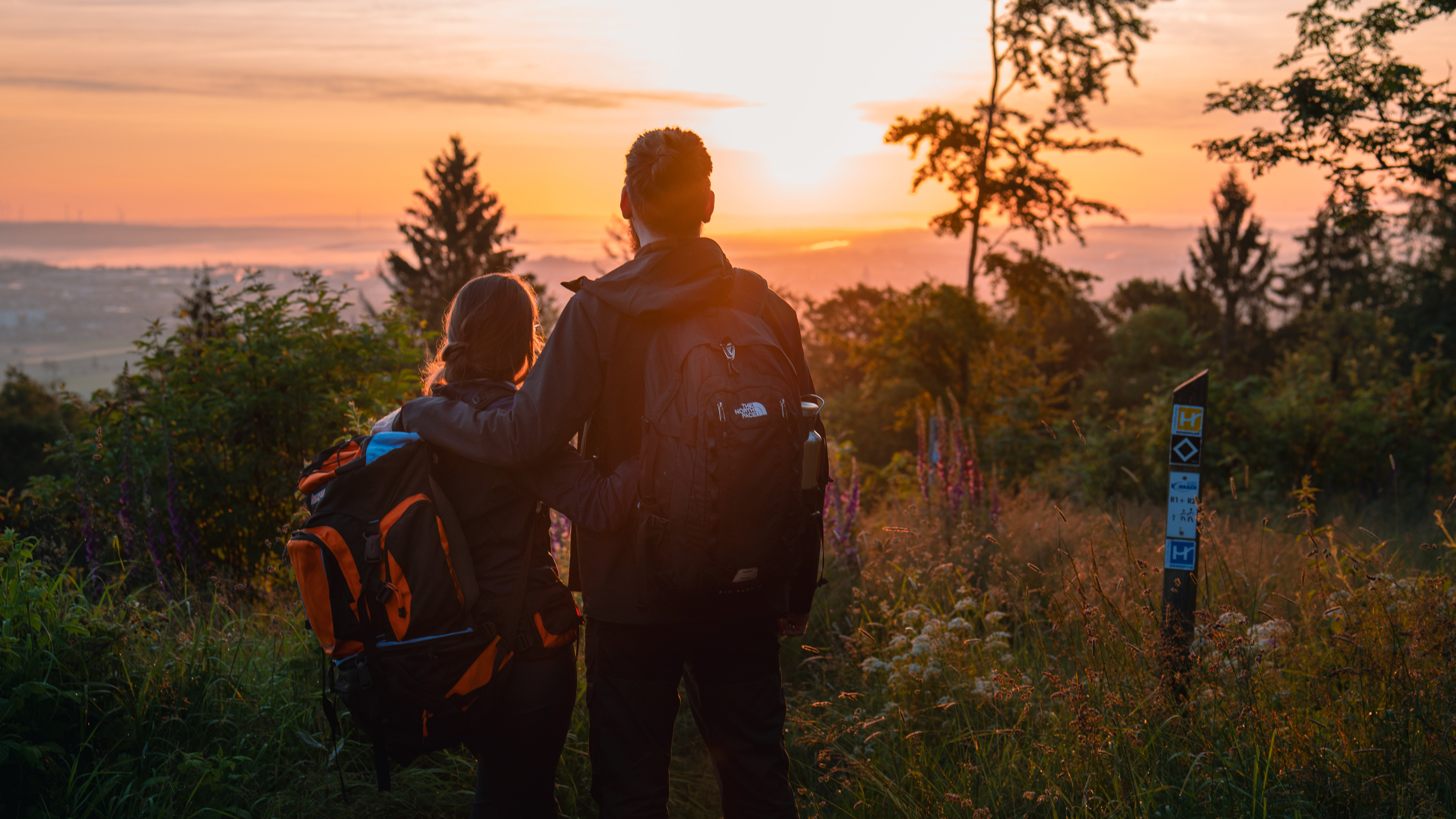 Wanderpaar vor Sonnenaufgang am Eisenberg in Korbach